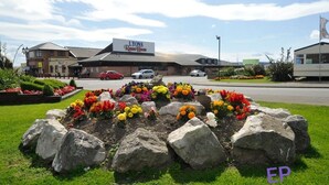 Un hôtel appelé « LYONS » qui dispose d’un jardin agrémenté de fleurs colorées et de gros rochers.
