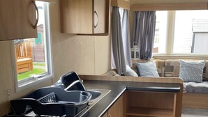Une cuisine compacte avec des meubles en bois, un plan de travail noir et un évier encastré.