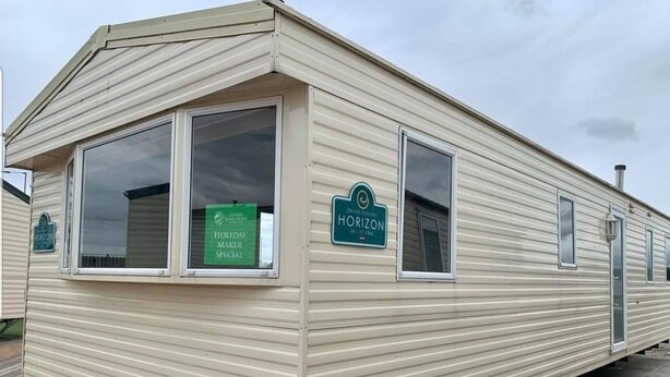 Une maison mobile avec une enseigne indiquant « Horizon » et une autre précisant « Offre spéciale pour les vacanciers ».