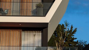 A modern building with a geometric design, large windows, and a balcony with plants. - The Shipyard Angra (Angra do Heroismo)