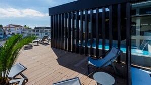 A rooftop terrace with a pool, lounge chairs, and a view of the city. - The Shipyard Angra (Angra do Heroismo)