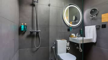 Et moderne badeværelse med bruser, toilet, vask og to spejle.