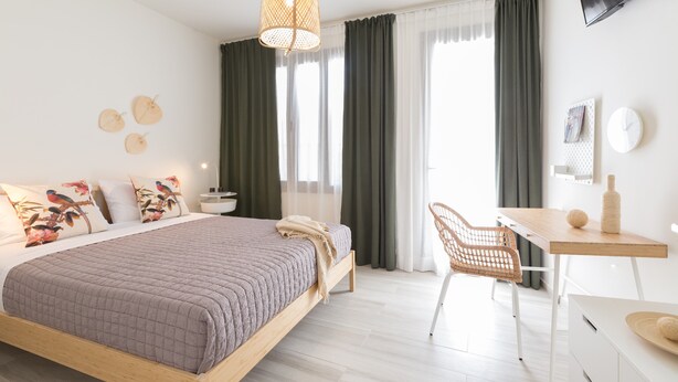 Un dormitorio moderno con una cama, un escritorio y una silla.