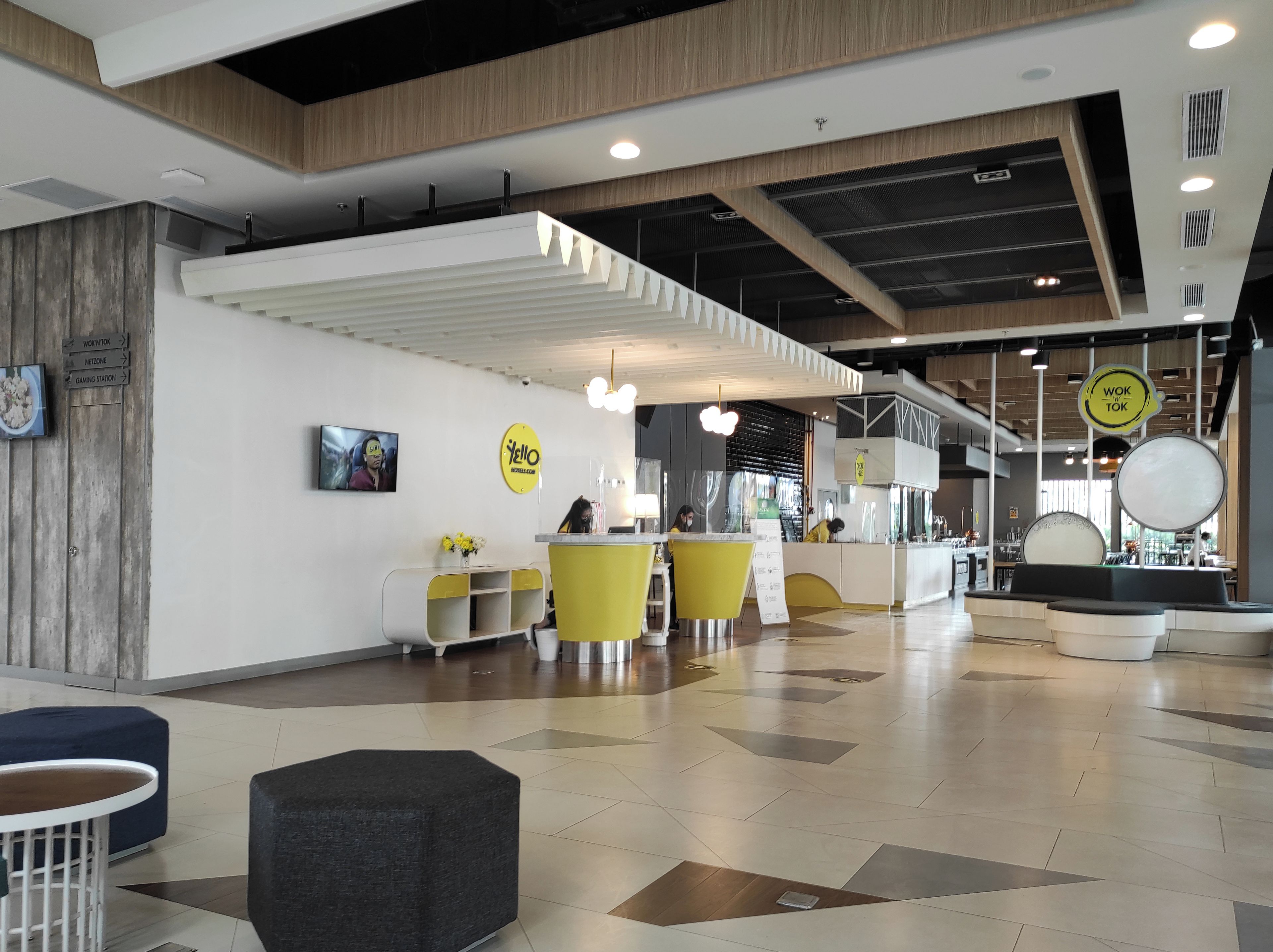 Un interior moderno con mostrador de recepción, zona de estar y señalización.