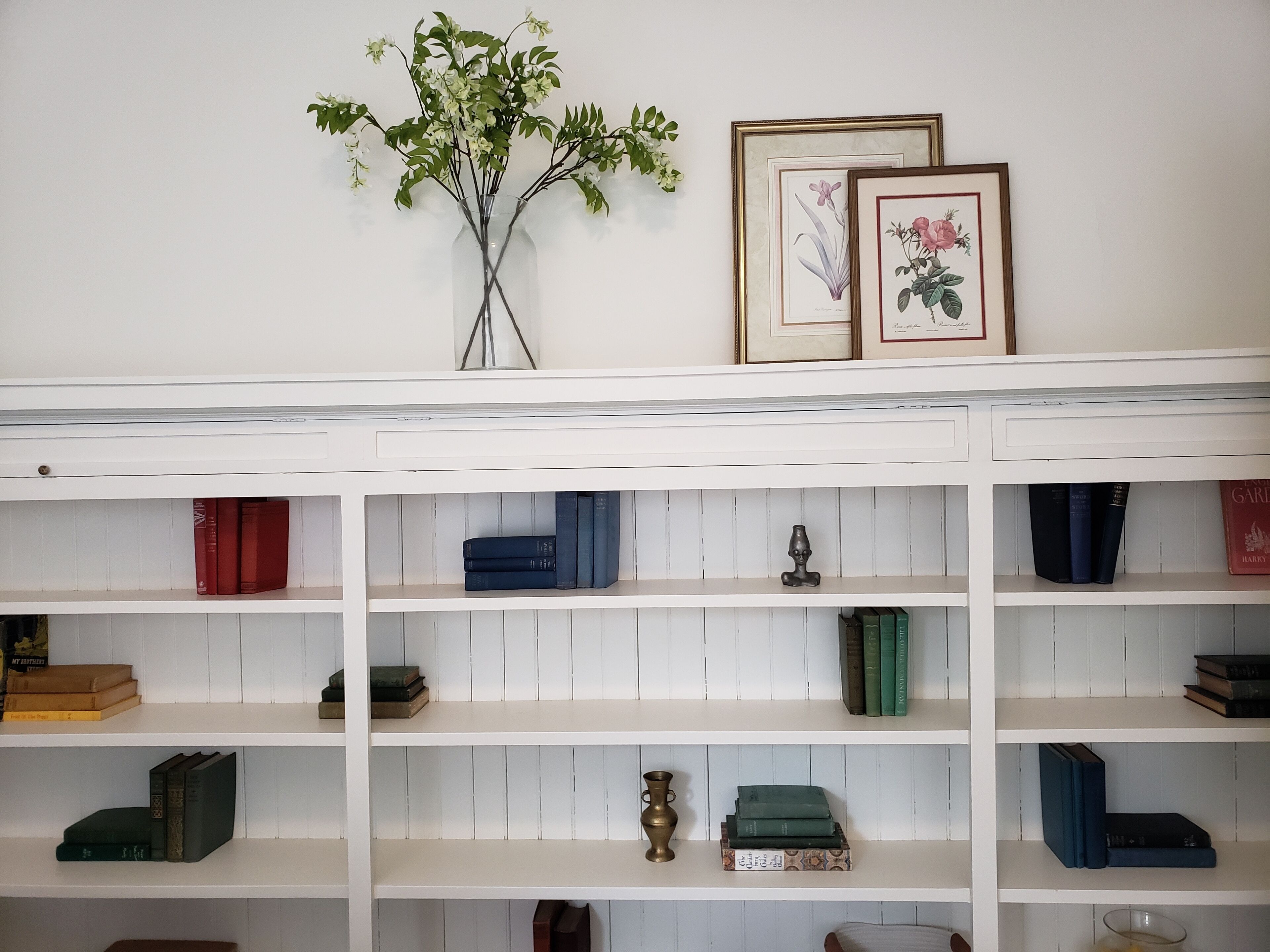 Una estantería con varios libros y objetos decorativos.