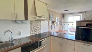 A kitchen with white cabinets, a dishwasher, a sink, and a Bosch refrigerator.