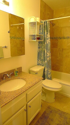 Une salle de bain comprenant un lavabo, des toilettes et un espace douche.