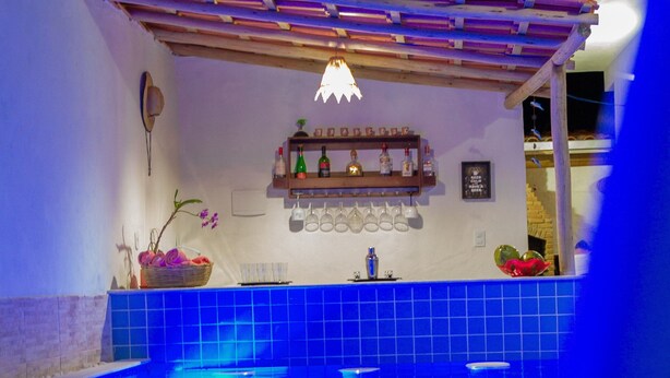 Ein Hallenbad mit Schachbrettmuster, einem Regal mit Flaschen und einem Hut an der Wand.