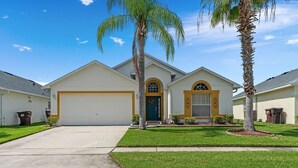 A single-story house with a garage, a front door, and two palm trees. - 4BR/3Bath Home, pool/spa, game room, lake view. Closer to ALL ATTRACTIONS (Kissimmee)