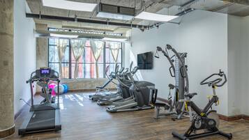 A gym with treadmills, elliptical machines, and a stationary bike.
