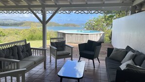 Un espace extérieur abrité, aménagé avec des sièges, et offrant une vue sur un lac et des montagnes.