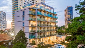 A multi-story hotel with balconies, a parking area, and surrounding high-rise buildings. - Hotel Solerios Mansa (Punta del Este)