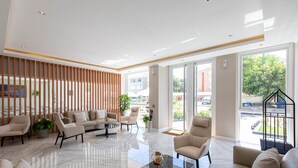 A spacious lobby with a marble floor, modern furniture, and large windows offering views of the outside. - Hotel Solerios Mansa (Punta del Este)