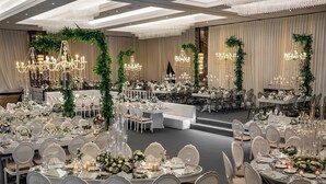 A banquet hall with round tables, white chairs, chandeliers, and floral decorations. - Crowne Plaza Ankara by IHG (Ankara)