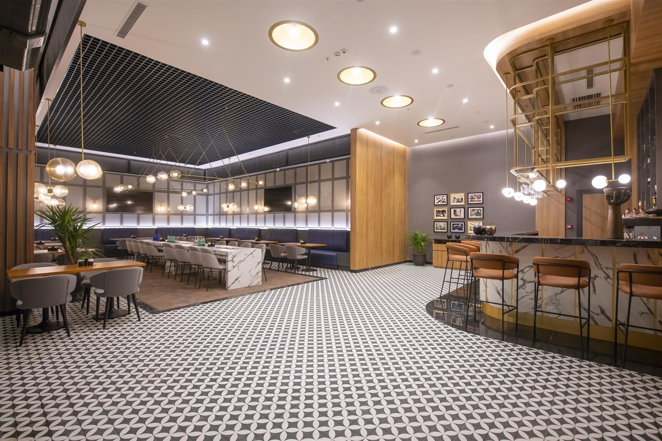 Un moderno vestíbulo de hotel con piso estampado, zonas de estar y un bar.