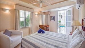 A hotel room with a bed, a chair, a desk, and a view of a pool. - Indramer Condos by Bluescape (Worthing)
