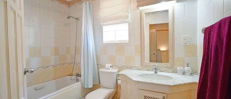 A bathroom with a bathtub, toilet, and sink.