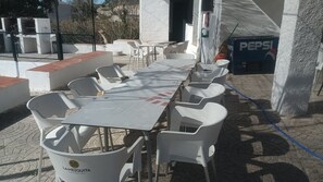 Enjoy dining al fresco at this outdoor patio with a long table and comfortable seating for all.