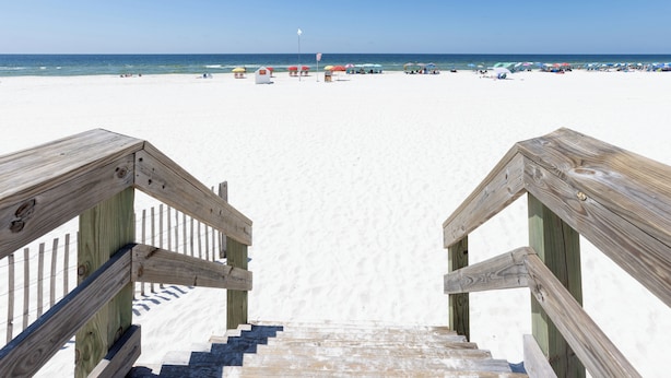 A wooden staircase leading to a beach with umbrellas and beachgoers in the distance. - "Sunshine At The Beach - Fall Specials! Many Upgrades! Perfect Location! (Orange Beach)