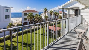 A balcony with a view of the beach, palm trees, and neighboring buildings. - "Sunshine At The Beach - Fall Specials! Many Upgrades! Perfect Location! (Orange Beach)