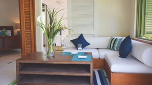 Una sala de estar con un sofá blanco, una mesa de centro de madera y un tapete a rayas.