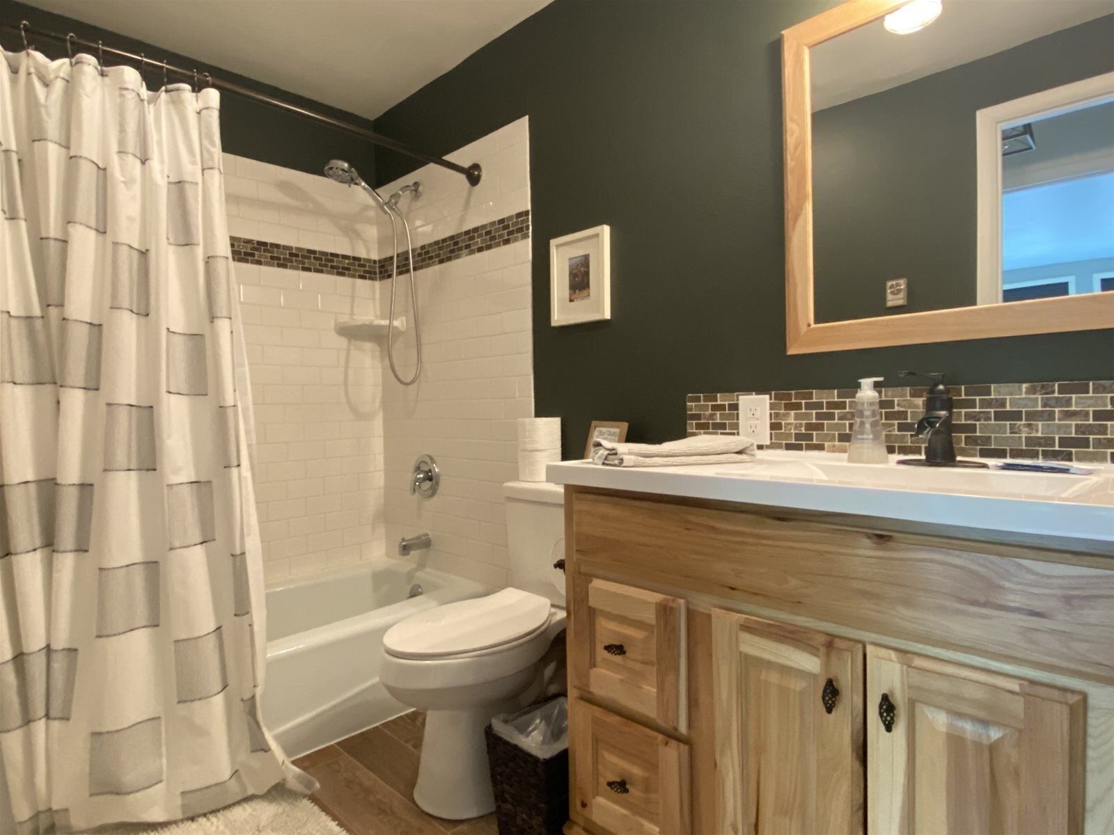 A bathroom with a shower, toilet, and vanity.