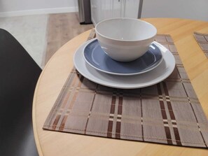 A dining table with a bowl and saucer on a placemat. - Cozy 2 bedroom basement (Winnipeg)