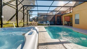 A covered outdoor swimming pool with lounge chairs and a hot tub. - SKC Villa Emerald Island Resort (Kissimmee)