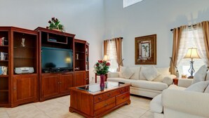 A living room with a sofa set, wooden entertainment unit, and a coffee table. - SKC Villa Emerald Island Resort (Kissimmee)