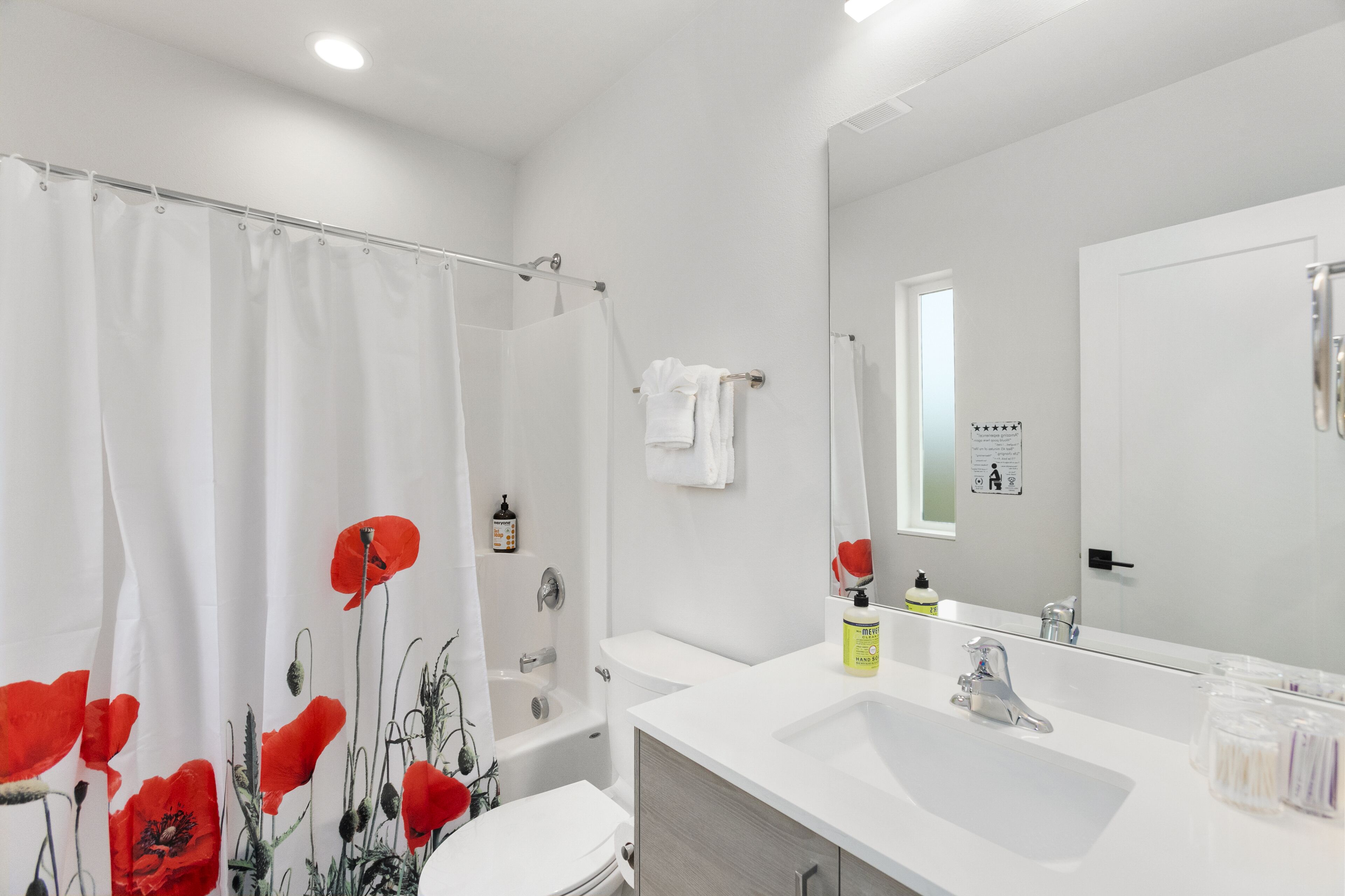 A modern bathroom with a shower, toilet, and sink.