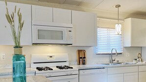 A modern kitchen with white cabinetry, a built-in microwave, a gas stove, and a dishwasher. - Convenient NE Albuquerque location, right off I-25!! (Albuquerque)