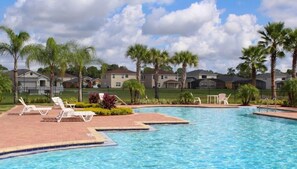 A swimming pool with lounge chairs and palm trees. - Disney Adventure 4Bdm 3b Private Pool (Kissimmee)