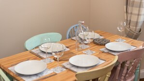 A dining table set with plates, wine glasses, and cutlery. - Beautiful 200 year old Cottage near St Andrews (Markinch)