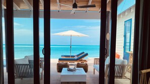 A wooden deck with lounge chairs and an umbrella overlooking the ocean. - IslandChicBeachFrontHome!StunningViews-Pool,OutdoorKitchen,Reef,Mini BballCourt (Rokers Point Settlement)