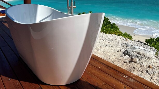 A white freestanding bathtub on a wooden deck overlooking a beach with turquoise waters and a clear sky. - IslandChicBeachFrontHome!StunningViews-Pool,OutdoorKitchen,Reef,Mini BballCourt (Rokers Point Settlement)