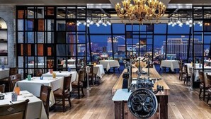 A restaurant with a long counter, wooden flooring, and a view of a cityscape. - Immaculate Views in Las Vegas High Rise Corner Unit  (Las Vegas)