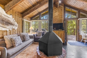Un interior de madera con chimenea, un sofá y un televisor.