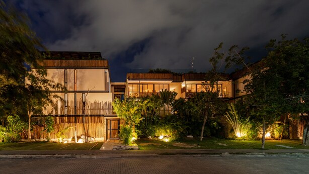 A modern building with a flat roof, large windows, and a well-lit entrance. - Two Bedroom Luxury Apartment by TuLuna (Tulum)