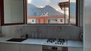 Una cocina moderna con un ventanal grande, horno empotrado y estufa a gas.