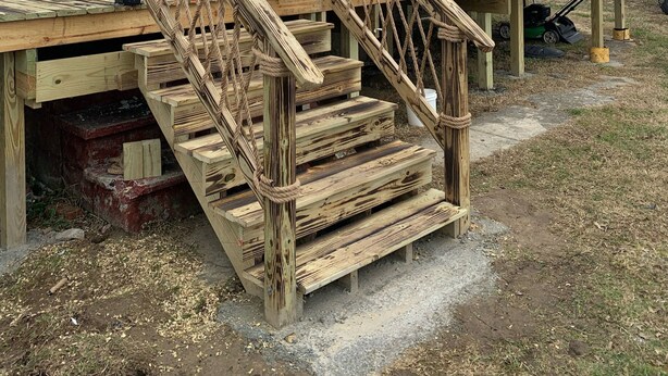 Una scala di legno che conduce a una casa con un'entrata per garage.
