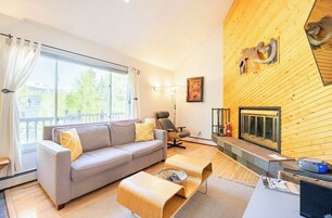 Uma sala de estar moderna com sofá, mesa de centro e lareira.