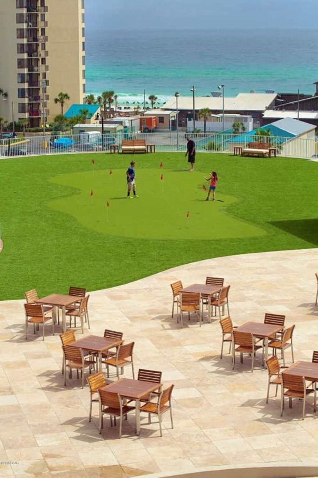 A patio area with outdoor seating and a view of the ocean.