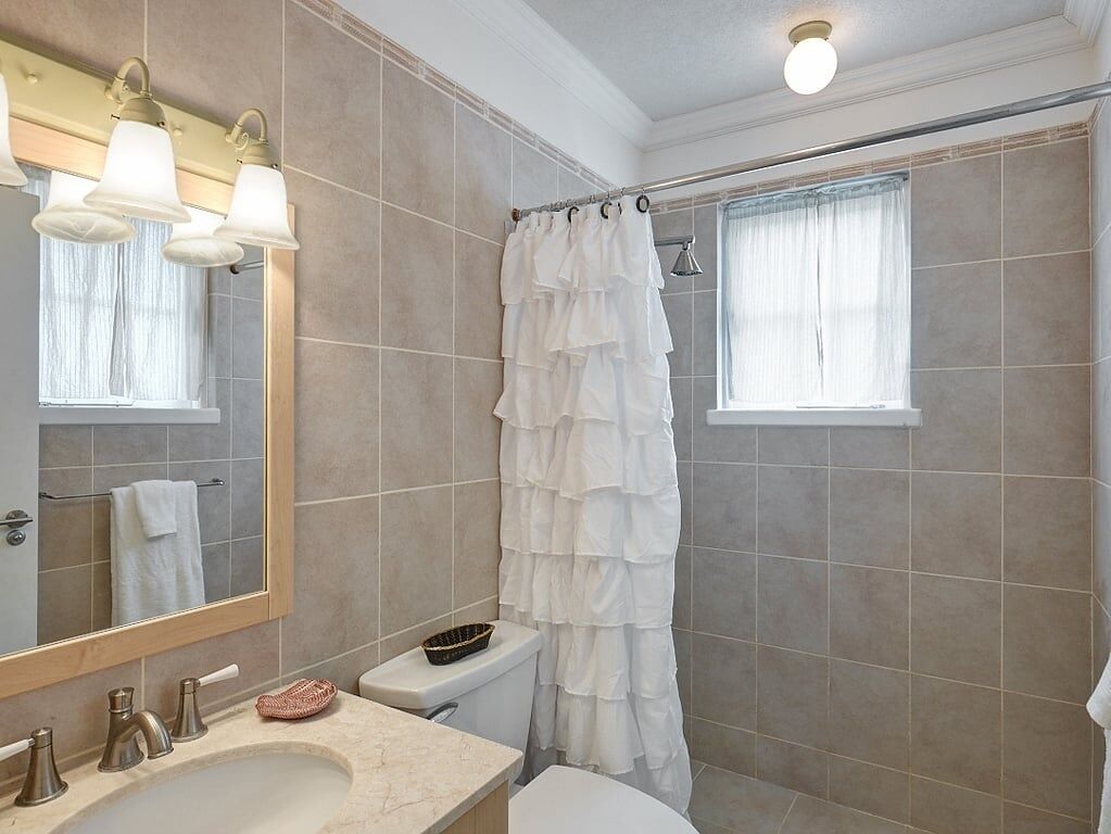 Une salle de bain avec un lavabo, un miroir et des toilettes.