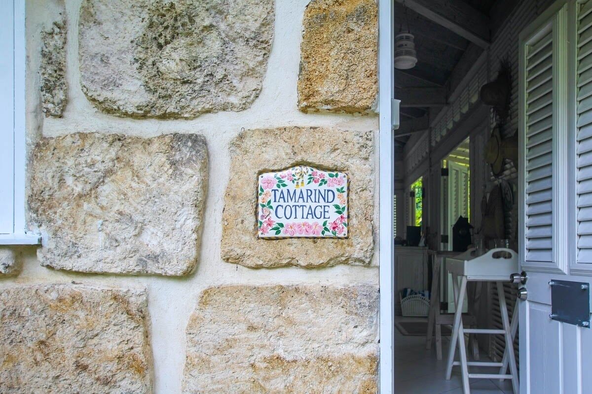 A stone wall with a sign reading "Tamarind Cottage."