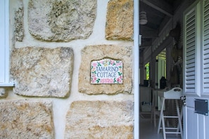 Un mur de pierres sur lequel est apposée une plaque indiquant : « Tamarind Cottage ».
