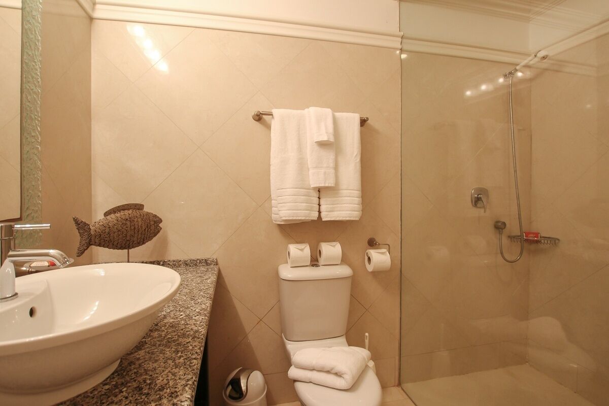 A bathroom with a sink, toilet, and shower.