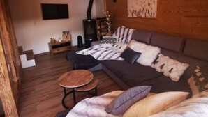A modern living room with a sofa, a round coffee table, and a fireplace. - New chalet Méribel (Méribel)