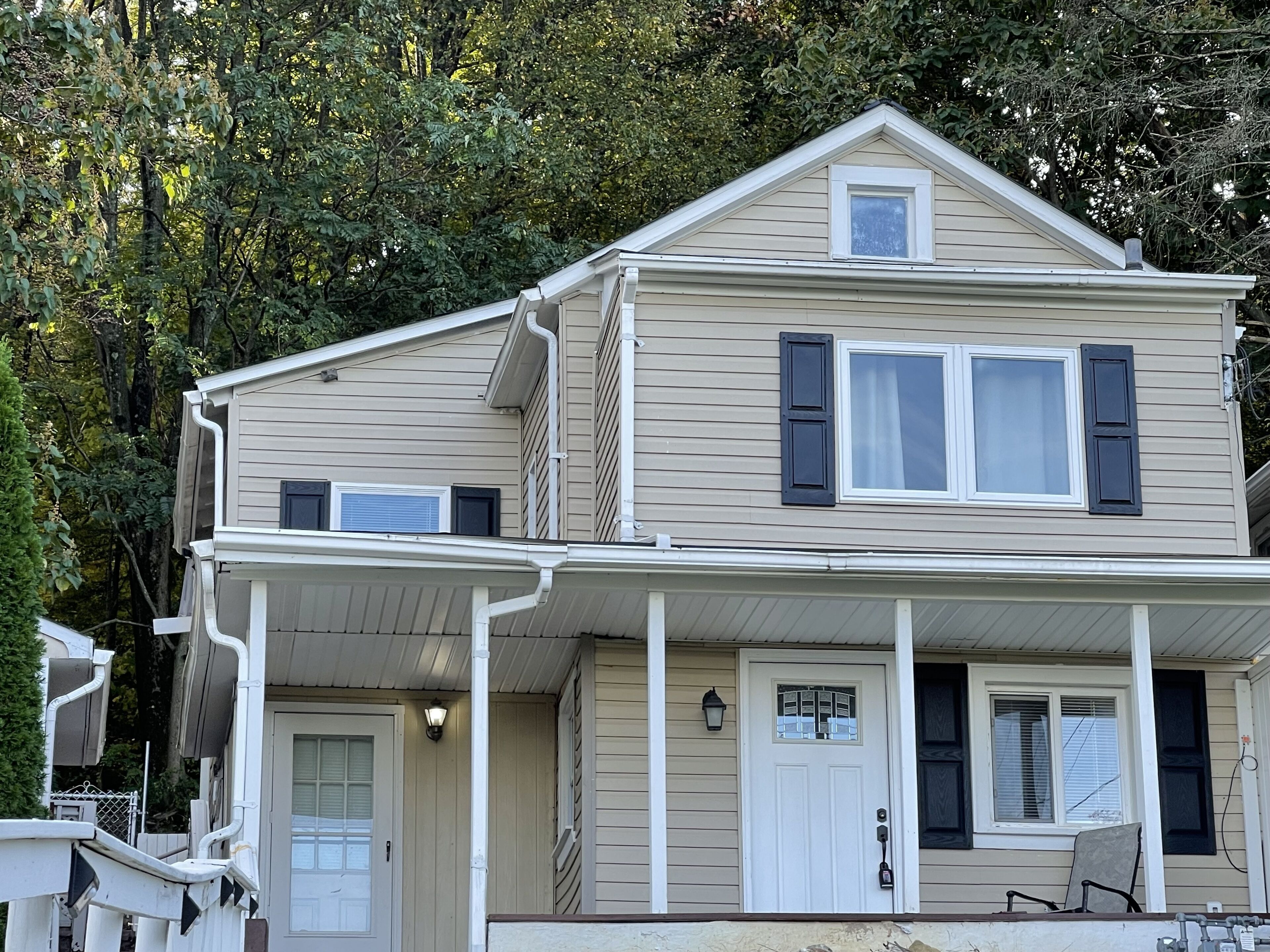 A two-story house with a front porch, a small balcony, and a garage.
