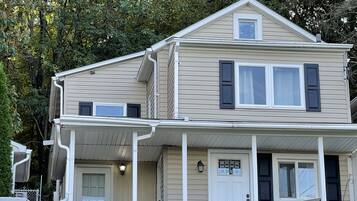 A two-story house with a front porch, a small balcony, and a garage.
