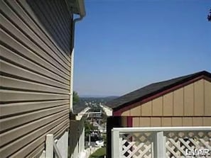 Stunning home with a sloped roof and front yard, surrounded by a white fence.